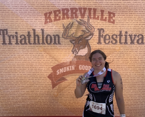A record number of triathletes registered for the 2019 Kerrville Triathlon, including this female sprint finisher posting in front of the Kerrville Tri sign.