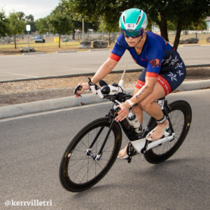 Cyclist takes the corner for the final turn before transition at the Kerrville Triathlon. Credit Ed Sparks.