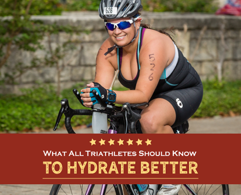 Female triathlete smiles for the camera while riding her bike. Text on design reads What All Triathletes Should Know to Hydrate Better. Learn more at http://kvy.b5e.myftpupload.com/2021/03/hydrate-better/