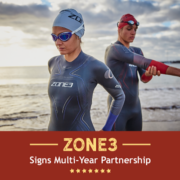Two triathletes prepare for an open water swim in their Zone3 wetsuits. Text on design reads Zone3 Signs Multi-Years Partnership. Learn more at http://kvy.b5e.myftpupload.com/2021/05/zone3-usa-partnership/