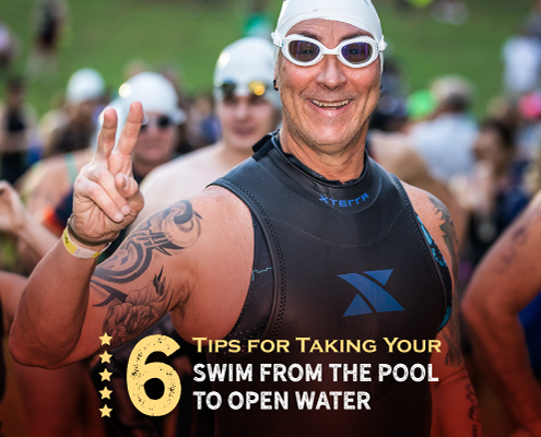 Triathlete shows the peace sign to the camera before he swims in Nimitz Lake at Kerrville Triathlon. He's in a sleeveless wetsuit with his swim goggles and swim cap. Text on design reads 6 Tips on Taking Your Swim from the Pool to Open Water. Read more at http://kvy.b5e.myftpupload.com/2021/07/from-the-pool-to-open-water/