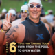 Triathlete shows the peace sign to the camera before he swims in Nimitz Lake at Kerrville Triathlon. He's in a sleeveless wetsuit with his swim goggles and swim cap. Text on design reads 6 Tips on Taking Your Swim from the Pool to Open Water. Read more at http://kvy.b5e.myftpupload.com/2021/07/from-the-pool-to-open-water/